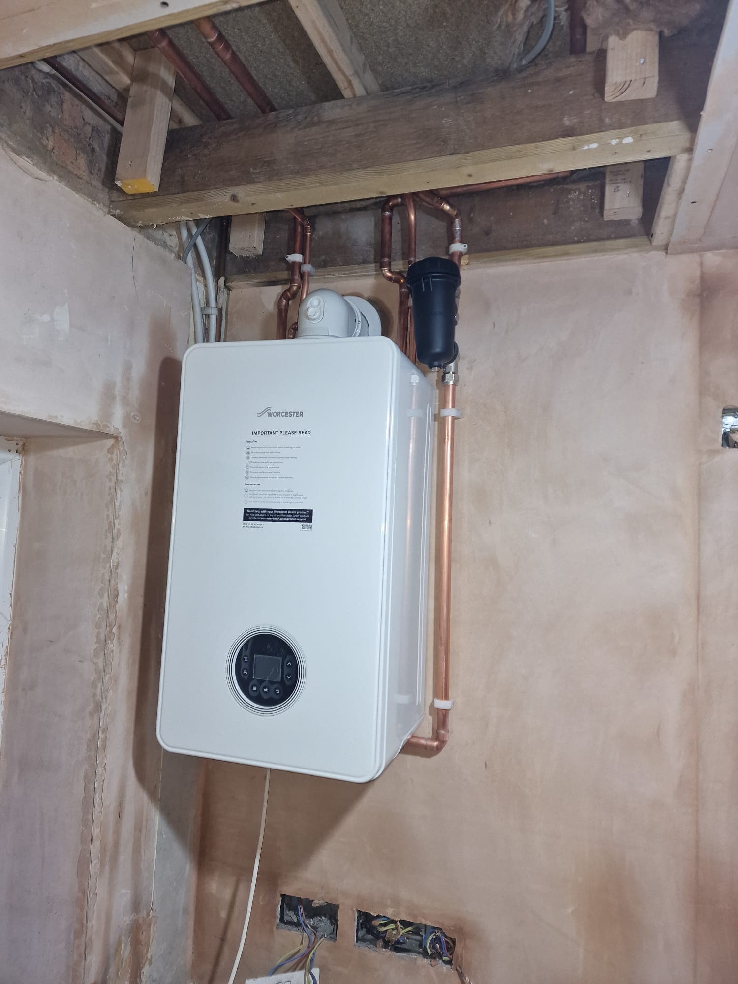 Worcester Bosch combi boiler on newly plastered wall with copper pipework and Adey magnetic filter